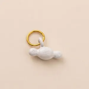 Primo piano di un anello in acciaio inossidabile placcato oro 18K con ciondolo bianco