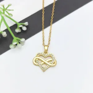 Primo piano di dettaglio di una collana con ciondolo cuore e infinito dorato con zirconi.
