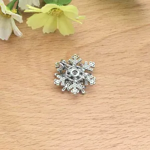 Gedetailleerd zicht op de achterkant van de sneeuwvlok broche met speld en hangeroog.