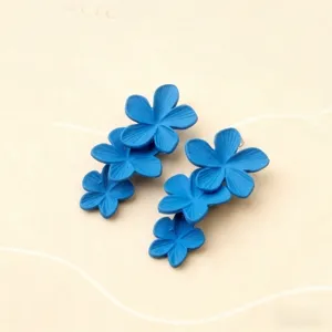 Primo piano dettaglio di orecchini pendenti blu a fiori, design elegante e trendy.