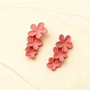 Dettaglio di orecchini pendenti con fiori rosa chic dal design floreale impilato.