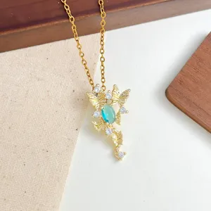 Primo piano dettagliato di una delicata collana d'oro con pendente in pietra blu e cristalli.