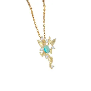 Collana con ciondolo dorato con pietra ovale blu e zirconi scintillanti su sfondo bianco