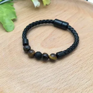 Vista dettagliata del bracciale in pelle intrecciata nera con chiusura magnetica e perle.