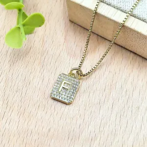 Collana con ciondolo lettera F in zirconi micro-incastonati dorati, vista dettaglio raffinata.