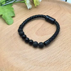 Vista dettagliata del bracciale in pelle intrecciata nera da uomo con perle di pietra.
