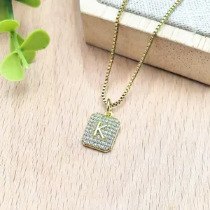 Collana con ciondolo lettera K in zircone quadrato dorato vista dettagliata per donna elegante.