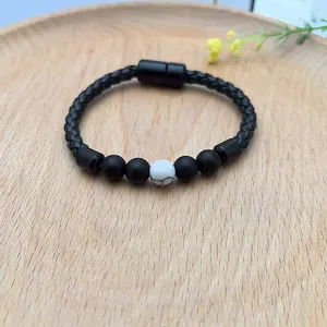 Vista dettagliata del bracciale in pelle intrecciata nera con chiusura magnetica e perle.