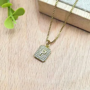 Dettaglio in primo piano della collana con ciondolo lettera P placcato oro con zirconi luminosi.
