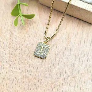 Bellissima collana con ciondolo lettera T in zirconi dorati, ottima vista di dettaglio.