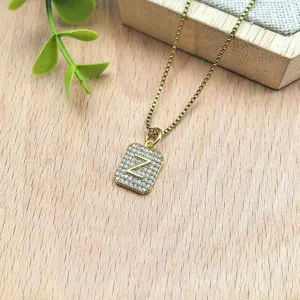 Primo piano dettagliato della collana con ciondolo a lettera Z in zircone dorato su legno.