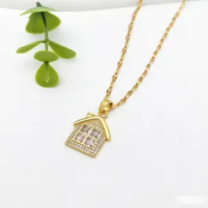 Primo piano dettagliato della collana con ciondolo a forma di casa dorata e pietre di zircone brillanti.