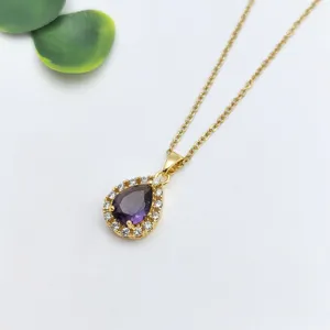 Primo piano dettagliato di una collana con ciondolo in pietra viola a goccia lucente.