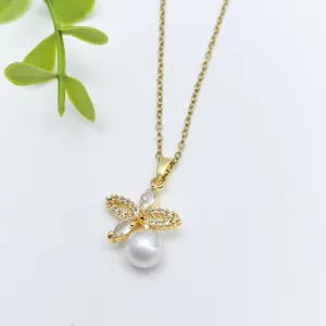Primo piano di una collana placcata in oro con zirconi scintillanti e pendente di perla bianca.