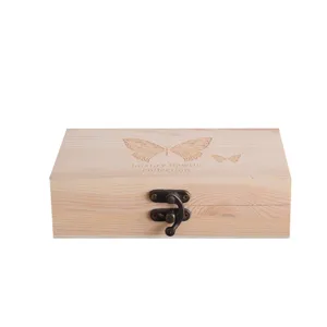 Dettaglio della scatola in legno con chiusura metallica vintage e incisione a farfalla.