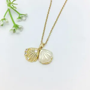 Collana con ciondolo a doppia conchiglia dorata con dettagli in zircone, dettaglio gioiello.