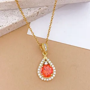 Squisita collana con pendente a goccia con zirconi arancioni brillanti e catenina dorata fine.