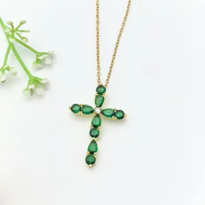 Dettaglio ravvicinato della collana con ciondolo a croce in zircone verde brillante.
