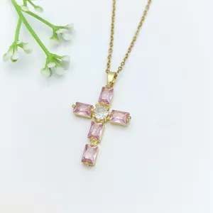 Collana con ciondolo a croce color oro con zirconi cubici rosa e pietra centrale.