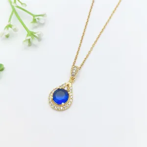 Elegante collana con pendente a goccia dorata con cristallo blu scuro e zirconi scintillanti.