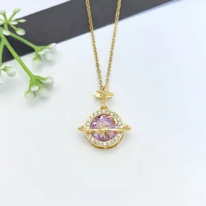 Primo piano della collana con ciondolo a forma di pianeta dorato, zirconi luminosi e stella delicata.
