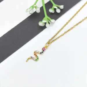 Dettaglio della collana con ciondolo a serpente dorato con pietre zirconi multicolore.