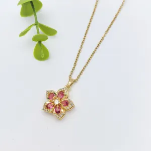 Vista dettagliata della delicata collana con ciondolo floreale dorato e pietre rosa brillanti.