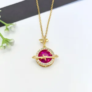 Primo piano di una collana con ciondolo pianeta celeste dorato, zirconi scintillanti e cristallo.