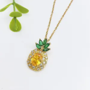 Primo piano dettaglio di una collana con ciondolo ananas alla moda con zircone giallo brillante.
