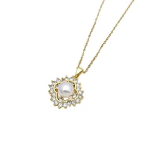 Collana con ciondolo a trifoglio dorato con perla centrale e zirconi cubici luminosi.