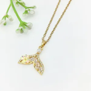 Elegante collana con ciondolo a coda di sirena dorata con zirconi brillanti e perla delicata.