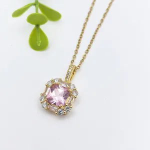 Primo piano dettagliato di una collana in acciaio inossidabile dorato con un ciondolo rosa.