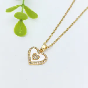 Primo piano di dettaglio della collana con ciondolo a doppio cuore in acciaio inox dorato.