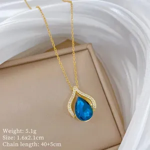 Elegante collana con pendente in cristallo blu a goccia e dettagli in zirconi su catena d'oro.