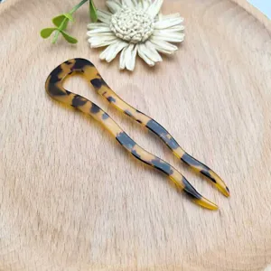 Primo piano dettagliato di un fermacapelli a U in acetato tartarugato stile retrò.