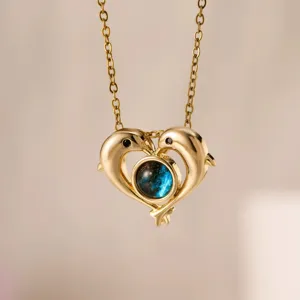 Primo piano della squisita collana con ciondolo a cuore doppio delfino e pietra centrale stellata.