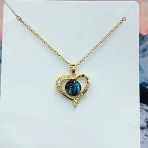 Collana con ciondolo a cuore placcato in oro con pietra galassia blu e dettagli in cristallo.