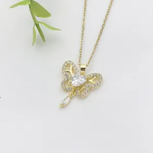 Primo piano di una collana con ciondolo a farfalla dorata con zirconi microincastonati brillanti.