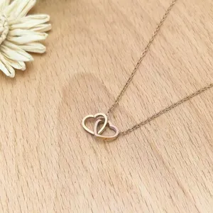 Double heart pendant necklace for women, elegant rose gold tone stainless steel chain jewelry.