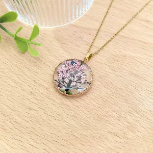 Vista dettagliata della collana con ciondolo di fiori secchi in resina vintage, artigianato raffinato.