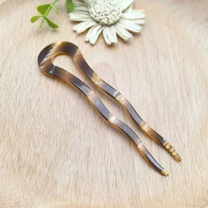 Primo piano dettagliato di un elegante fermacapelli in acetato tartarugato per acconciature.