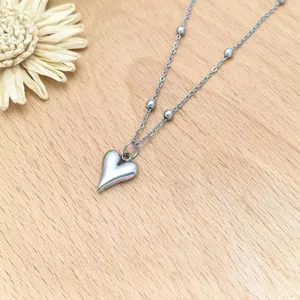 Detail view of stainless steel heart pendant necklace with delicate bead chain design.