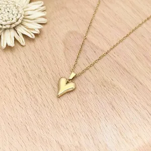 Chic golden stainless steel heart pendant necklace, exquisite detail shot for women daily fashion.