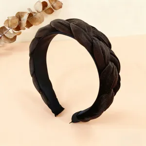 Dettaglio cerchietto treccia in velluto marrone scuro, design largo antiscivolo, accessorio inverno.
