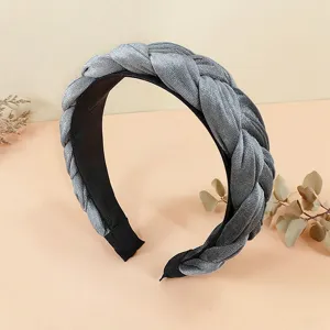 Primo piano del cerchietto treccia in velluto grigio, consistenza morbida, elegante accessorio