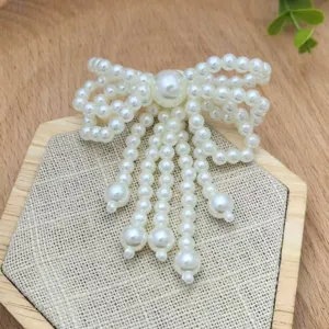 Dettaglio accessorio fiocco di perle, elegante design con perline bianche per gioielli.