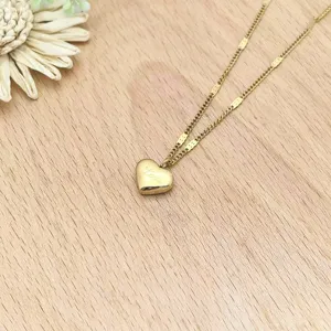 Stainless steel gold heart pendant necklace detail shot, elegant geometric chain link accessory.