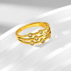 Primo piano dettagliato dell'anello in acciaio al titanio dorato con zirconi brillanti.