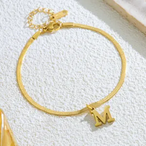 Goldfarbene Edelstahl Schlangenkette Fußkette mit M Anhänger und K18 Verlängerungsdetails.