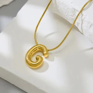 Gold letter G pendant necklace closeup detail view showing smooth metallic texture.